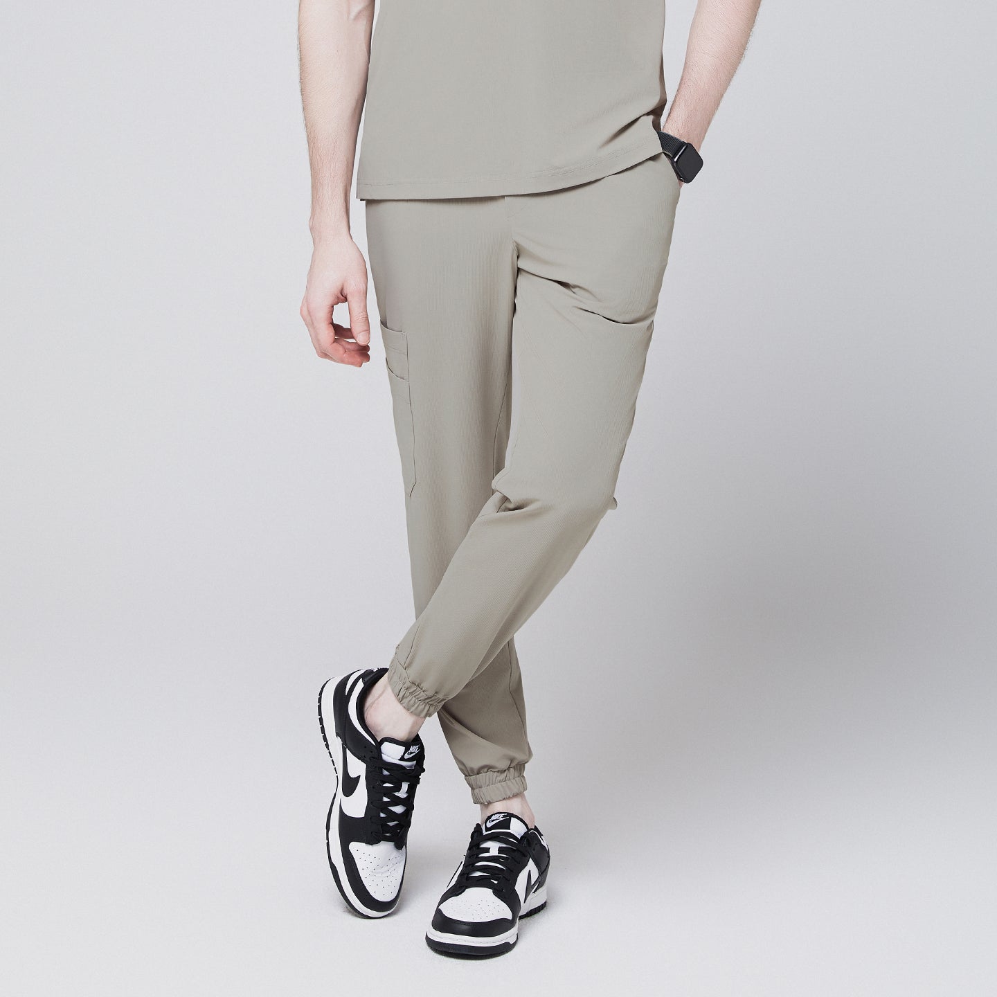 Image of Sand khaki jogger scrub pants with side pocket and elastic cuffs, paired with black and white sneakers,Sand Khaki
